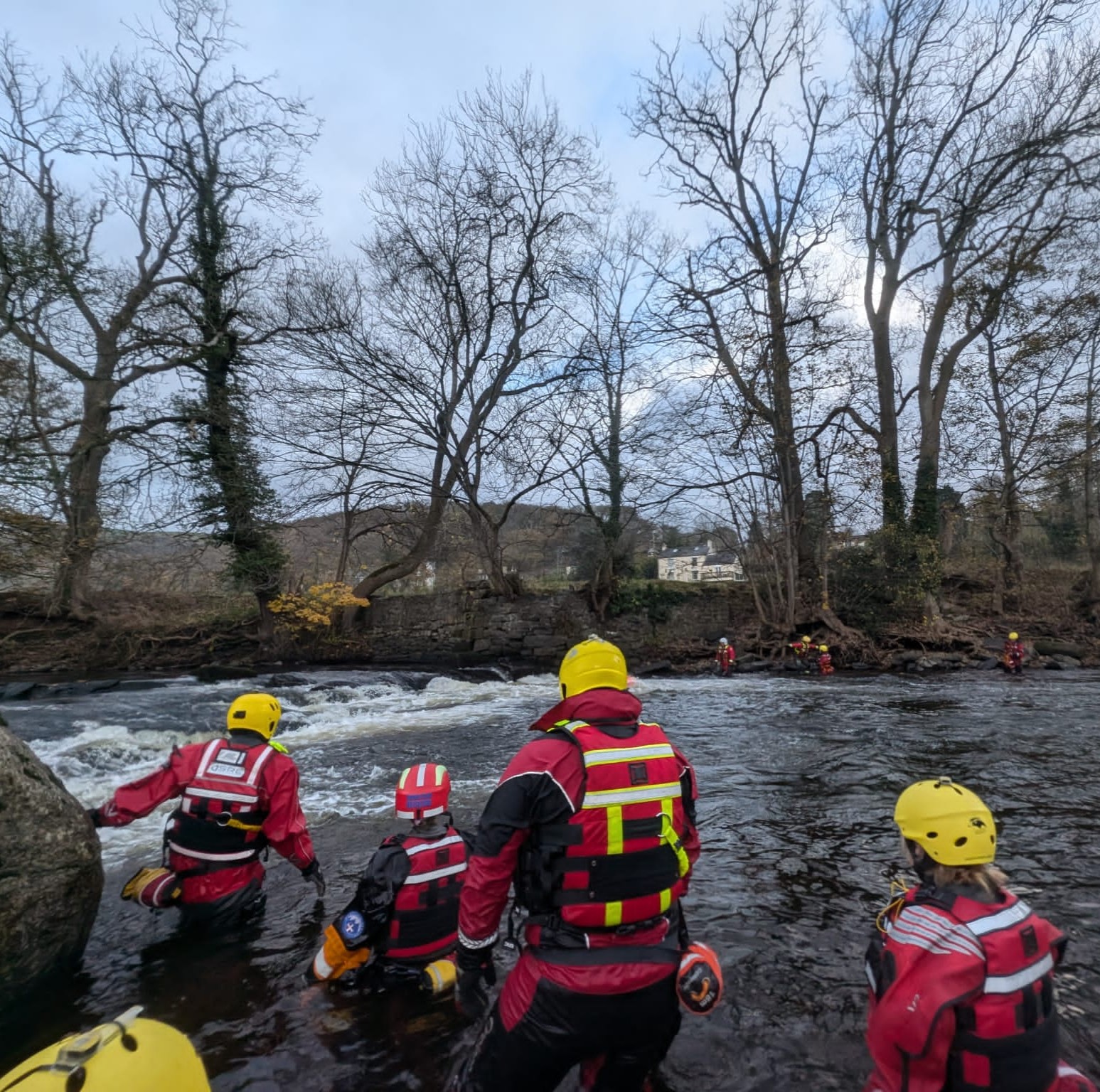 Team members in a river practicing river rescue skills.